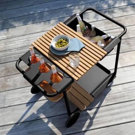 Servierwagen mit Getränken und Oliven auf Holzterrasse