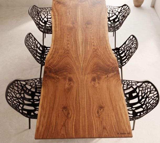 Moderner Massivholztisch mit sechs schwarzen Designerstühlen in minimalistischem Raum.